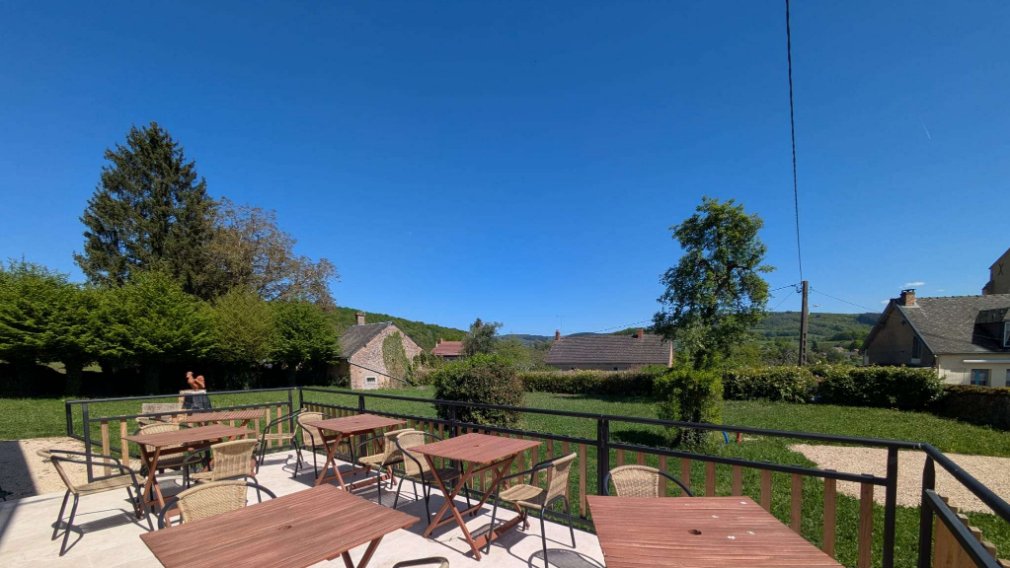 Terrasse équipée de tables et chaises – Vue dégagée sur le village et les collines Terrasse & jardin